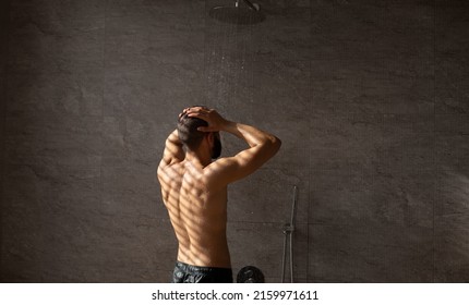 Male Bodycare Routine, Everyday Hygiene Concept. Back Rear View Of Muscular Guy Taking Shower Washing Head Standing Under Falling Hot Water Drops In Modern Bathroom, Banner, Free Copy Space Mockup