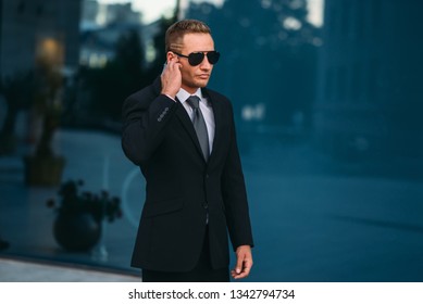 Male Bodyguard Uses Security Earpiece Outdoors