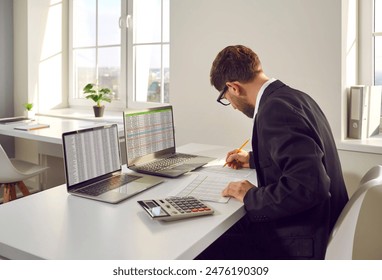 Male bookkeeper working with financial report in in office. Man accountant or financial manager working with taxes, loans, debit and credit operations. Audit, statistics, tax, accounting