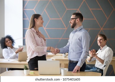 Male Boss Or Team Leader Shaking Hand Of Female Successful Employee Congratulating With Promotion Or Rewarding, Appreciating For Good Work Result  While Business Team Applauding, Recognition Concept