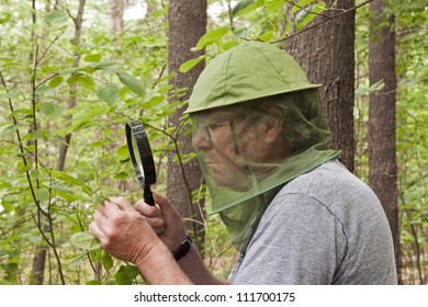 male botanist inspecting a plant with a magnifying glass - Powered by Shutterstock