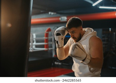 Male boxer training with punching bag in a boxing gym. - Powered by Shutterstock