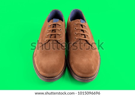 Male brown leather elegant shoe on green background, comfortable footwear.