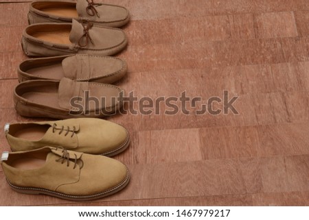 male brown loafer with suede shoes, comfortable footwear.on brown wooden background
