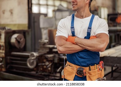 Male builder with athletic arms standing at construction site - Powered by Shutterstock