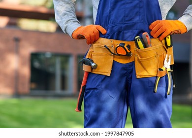 Male Builder In Blue Overalls Wearing Tool Belt. Close Up On Waist Area