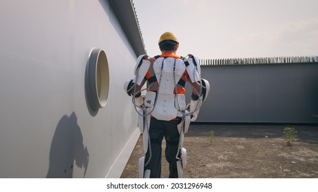 Male Builder In Exoskeleton Walking On Construction Site