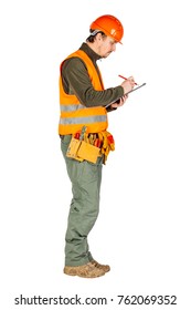 Male Builder Or Manual Worker In Helmet Writing On Clipboard Over White Wall Background. Repair, Construction, Building, People And Maintenance Concept