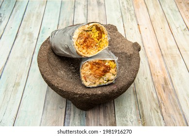 Male Burrito With Chipotle Sauce On Natural Stone Mortar On Wooden Table