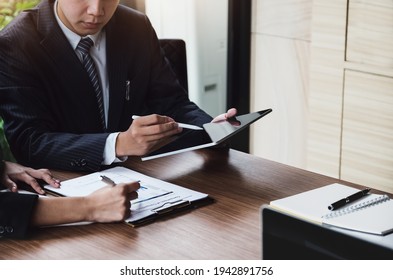 A Male Business Consultant Describes A Marketing Plan To Set Business Strategies For Women Business Owners Witch Using Ipad.