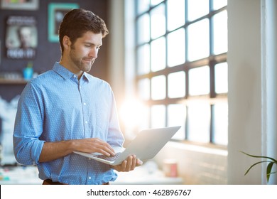 Male Business Executive Using Laptop In Office