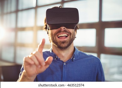 Male Business Executive Using Virtual Reality Headset In Office