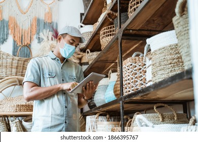 male business owner keep working and wear face masks at his art and craft store