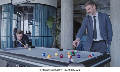 Male Business Partners Playing Billiards And Discussing Cooperation In Office