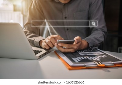 Male Business Working In The Work Area With Smartphones And  Searching For Information Data Sheets At The Desk.