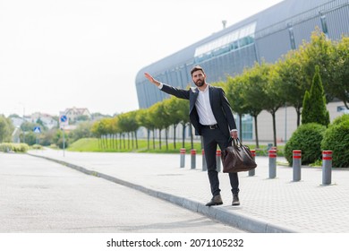 Male Businessman Can Not Catch Free Taxi At Busy Time. Business Man Does Not Successfully Stop A Taxi On A City Street. Can't Catch A Car On The Road Waving His Hand. Standing On The Sidewalk Outside