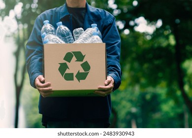 Male businessman holds a cardboard box with a water bottle and a recycling symbol. Recycling concept use of green technology Invest in green business Good green organization, clean community, etc.