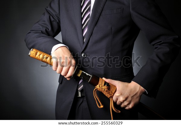 日本の武士の刀を持つためにスーツを着た男性実業家 の写真素材 今すぐ編集