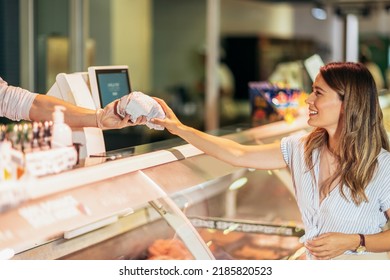 Male butcher giving meat to female customer at butchery - Powered by Shutterstock