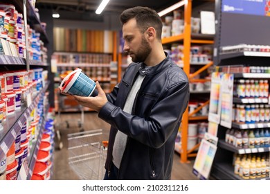 Male Buyer Chooses Paint In A Hardware Store, Concept Of Finishing Exterior And Interior Walls