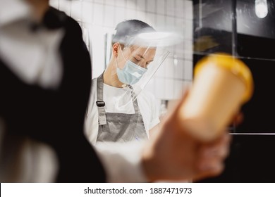 Male Cafe Employee Wearing Masks Against Virus, Coronavirus, Pandemic, Infection. Small Business Stylish Cafe Restaurant.