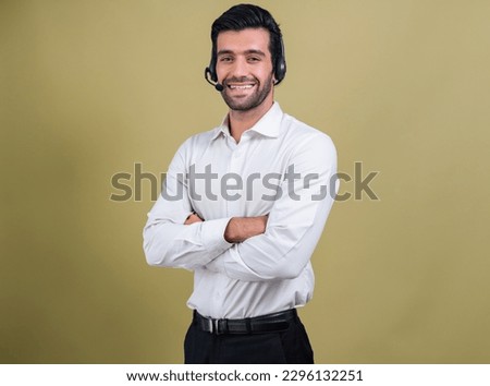 Male call center operator wearing headset and formal suit standing confidently on isolated background portrait. Professional smile and service minded for customer service and support. fervent
