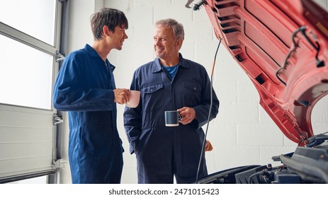 Male Car Auto Mechanic With Trainee On Coffee Break In Auto Repair Shop - Powered by Shutterstock