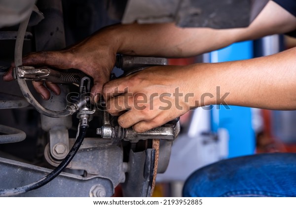 Male car mechanic examining brake\
disc.Car brake repairing in garage.Selective focus disc brake on\
car. Car disk brake system service\
concept