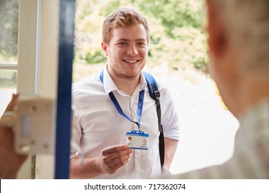 Male Care Worker Showing ID To Senior Man At His Front Door