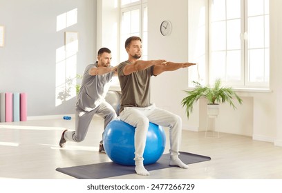 Male caregiver or doctor physiotherapist helping young man doing sport exercises sitting on fit ball in rehabilitation center helping patient in rehab. Physiotherapy and rehabilitation concept. - Powered by Shutterstock