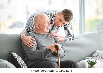 Male Caregiver With Senior Man In Nursing Home