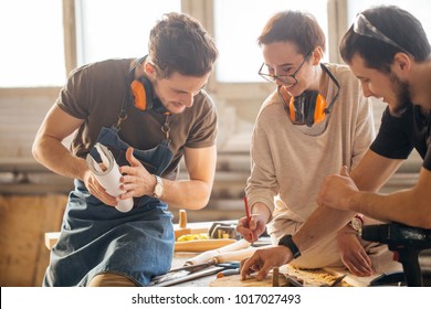 male Carpenter Training Female Apprentice To Use Plane - Powered by Shutterstock