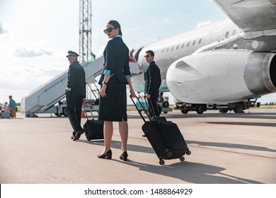 Male Caucasian pilots and attractive stewardess walking in airport stock photo. Airways concept - Shutterstock ID 1488864929