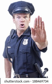 Male Caucasian Police Officer In Blue Cop Uniform Holds Up Hand In Stop Gesture On White Background