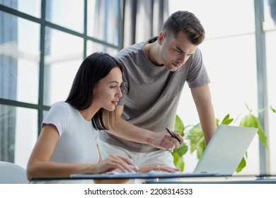 male ceo executive manager mentor giving consultation on financial operations to female colleague using laptop - Shutterstock ID 2208314533