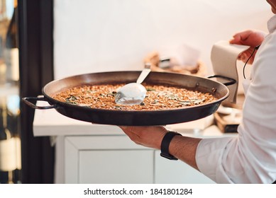 Male Chef With A Dish Of Paella In His Hands