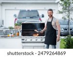 Male chef grilling and barbequing in garden. Barbecue outdoor garden party. Handsome man preparing barbecue meat. Concept of eating and cooking outdoor during summer time.