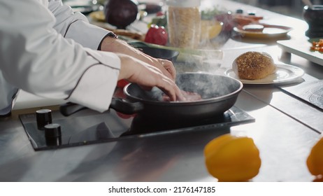 Male chef putting meat steak to cook in frying pan with olive oil, making delicious meal dish. Person cooking beef on stove to prepare cuisine food with culinary recipe. Close up. Hnadheld shot. - Shutterstock ID 2176147185