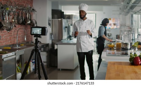 Male Chef Recording Cooking Show Television Vlog On Camera, Talking About Gastronomy And Culinary Recipe. Young Cook Filming Professional Cuisine Content For Online TV Program. Tripod Shot.