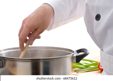 Male Chef Stirring Meal In Pot On Stove