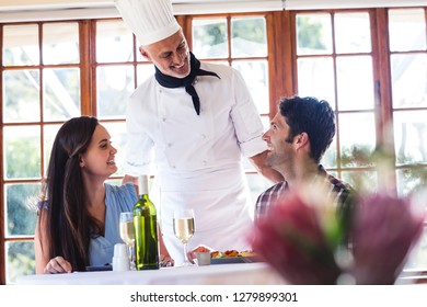 Male chef talking to couple at restaurant - Powered by Shutterstock