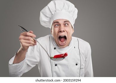 Male Chef In White Uniform Making Funny Face And Screaming While Trying Food With Red Hot Chili Pepper