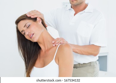 Male Chiropractor Doing Neck Adjustment In The Medical Office