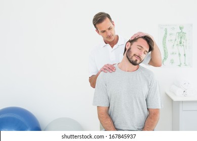 Male Chiropractor Doing Neck Adjustment In The Medical Office