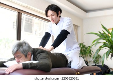 Male chiropractor and male elderly patient who perform leg massage - Shutterstock ID 2205620681