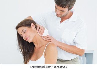 Male chiropractor massaging a young woman's neck in the medical office - Powered by Shutterstock