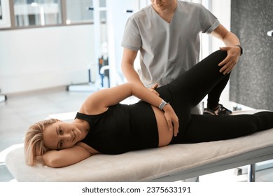 Male chiropractor working with his back expectant mother - Powered by Shutterstock