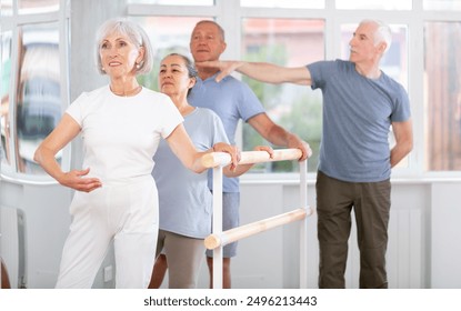 Male choreographer teaches elderly ballet lovers to keep their heads straight during a ballet lesson - Powered by Shutterstock