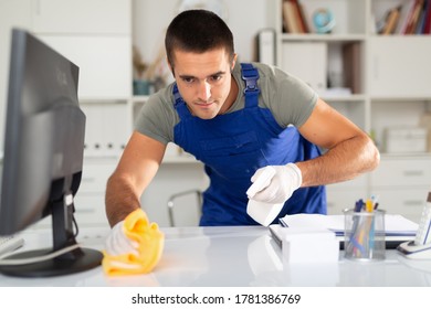 Male cleaner wipes table with rag in company office - Shutterstock ID 1781386769