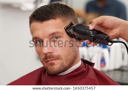 Male client getting haircut by hairdresser.
